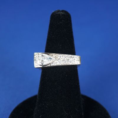 un gros plan d'une bague en diamant posée sur un présentoir noir