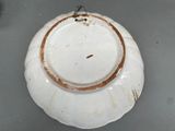 a white plate with a gold rim on a table