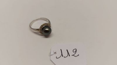 gros plan d'une bague sur une surface blanche avec une étiquette de prix