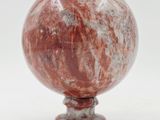 une photo d'une bille rouge posée sur un socle