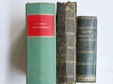 trois livres posés sur une table blanche