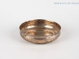 an image of a small brass bowl on a white surface