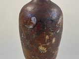 a brown vase sitting on top of a white table