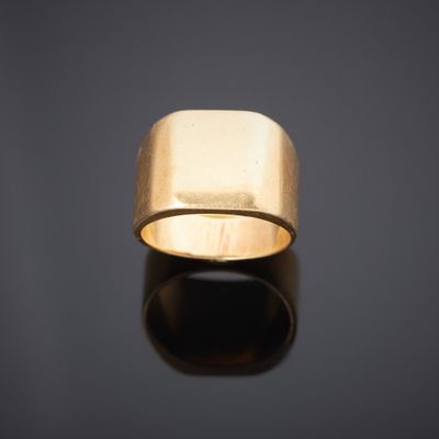 gros plan d'une bague en or sur une surface noire