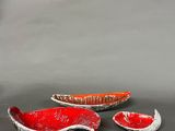 two red and white bowls sitting next to each other on a table