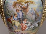 a vase with a painting on it sitting on a table