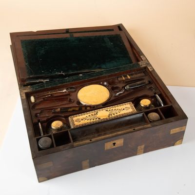 a wooden box with a writing set inside of it