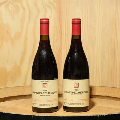 two bottles of wine sitting on top of a barrel