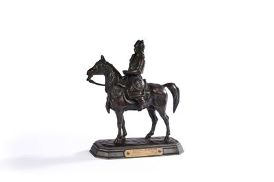 une statue représentant un homme à cheval, posée sur un socle en bois