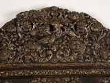 an ornate wooden headboard with a bird and flowers on it