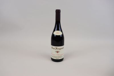 une bouteille de vin posée sur une table blanche