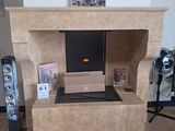 a fireplace with speakers and a picture on the wall