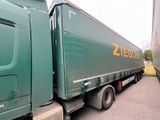 a green truck that is parked on the side of the road