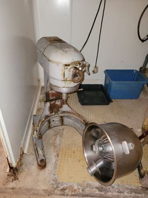 an old mixer sitting in the corner of a room