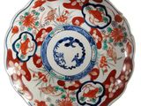 a red and blue plate with a flower design on it