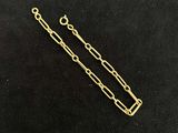 a close up of a gold plated chain on a black surface