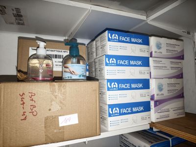 Des boîtes de masques sont empilées sur une étagère dans une pièce