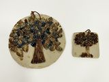 two pieces of pottery with a tree on them