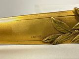 a gold knife with a leaf decoration on it