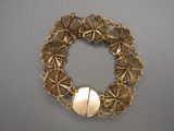 un gros plan d'un bracelet en or orné d'une boule