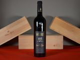 a bottle of wine sitting on a table next to two wooden boxes