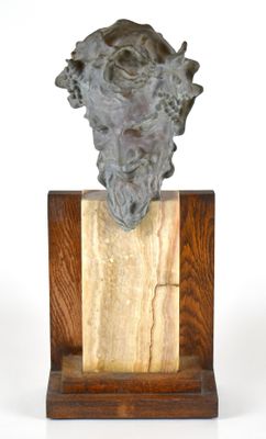 statue représentant la tête d'un homme barbu, posée sur un socle en bois