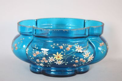 un bol en verre bleu orné de fleurs peintes
