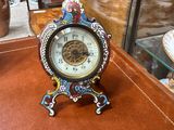 a small clock sitting on a table in front of a glass case