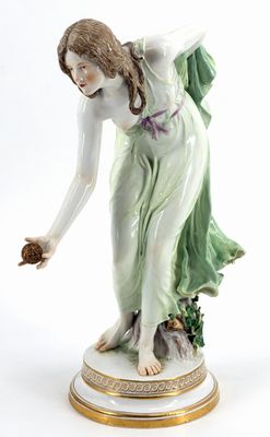 porcelain figurine of a woman holding a flower in her hand
