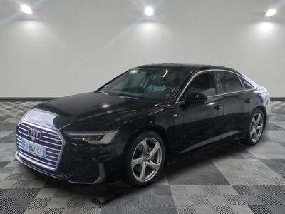L'Audi noire est garée dans une grande pièce au sol carrelé.