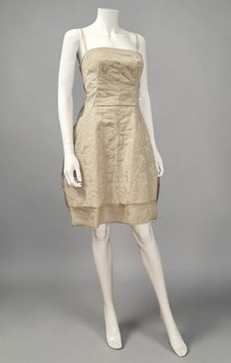 a mannequin wearing a tan dress and white shoes