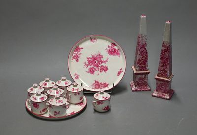 a pink and white plate and cups and saucer and a vase