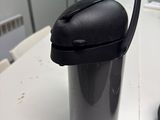 a black cup sitting on a table next to a computer mouse