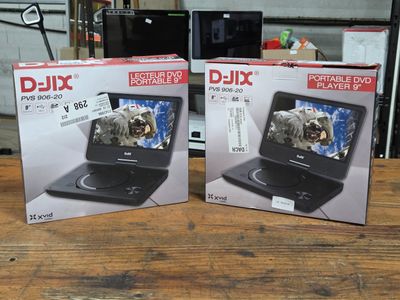 boxes of two portable dvd players sitting on top of a wooden table