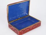 a small red box with a blue lid on a white surface