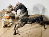 two wooden horses that are sitting on the floor