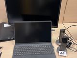 un ordinateur portable posé sur un bureau à côté d'un moniteur