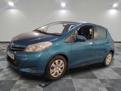 the small blue car is parked in the garage on a checkered floor