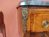 a close up of a wooden dresser with a marble top