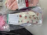 three pairs of mitts wrapped in plastic bags on a table