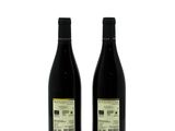two bottles of wine sitting next to each other on a white surface