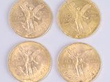 four gold coins with angel on them sitting on a white surface