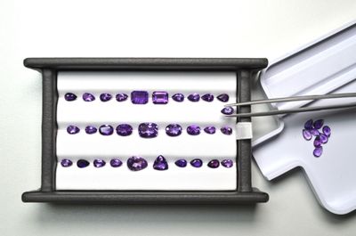 un plateau avec des pierres précieuses violettes et une paire de baguettes