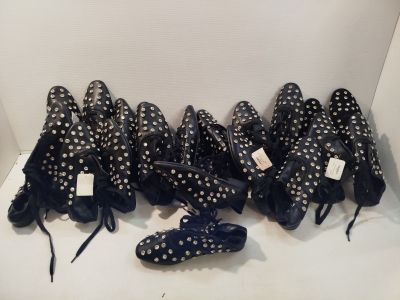 Plusieurs paires de chaussures sont alignées sur une surface blanche