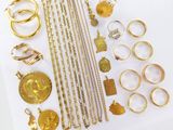 a lot of gold jewelry on a white surface