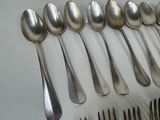 a lot of spoons and forks laid out on a table