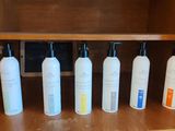 five bottles of lotion sitting on a shelf in a cabinet