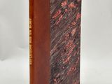 un livre à la couverture marron posé sur une surface blanche