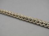 a close up of a silver chain bracelet on a gray surface