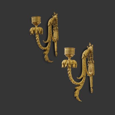 a pair of gold plated sconces on a black background